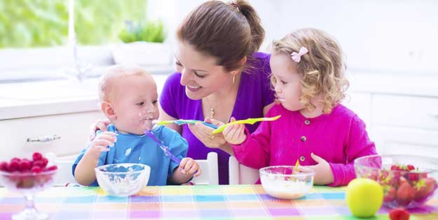 Mujer alimentando niños